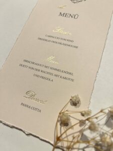 Menükarte mit Goldprägung und handgerissenen Kanten als individuelle Hochzeitspapeterie